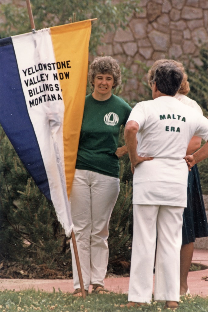 Yellowstone Valley NOW Dee Adams holding Yellowstone Valley NOW banner and Doris Brander (hometown Malta, Montana) with back to camera. At "Failure is Impossible" celebration in Helena, Montana, to promote passage of the Equal Rights Ammendment. July 1, 1982 