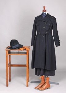 World War I military nurse's uniform on a mannequin, displayed with boots, hats, and gloves